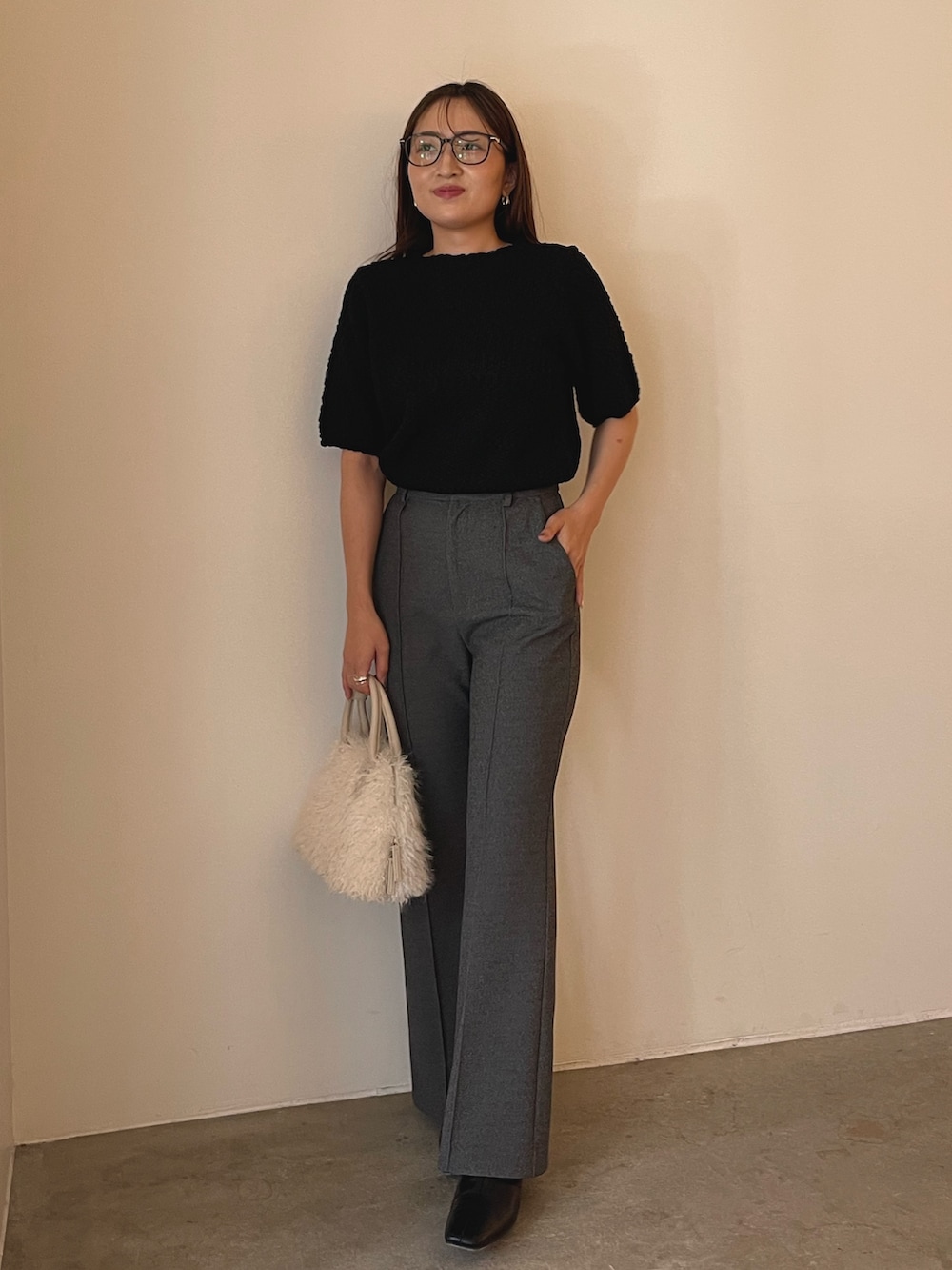 ホワイト系のボストンバッグ、ブラック系のブーツ、ブラック系のニット/セーターを着用したレディースの夏コーディネートの5枚目の写真