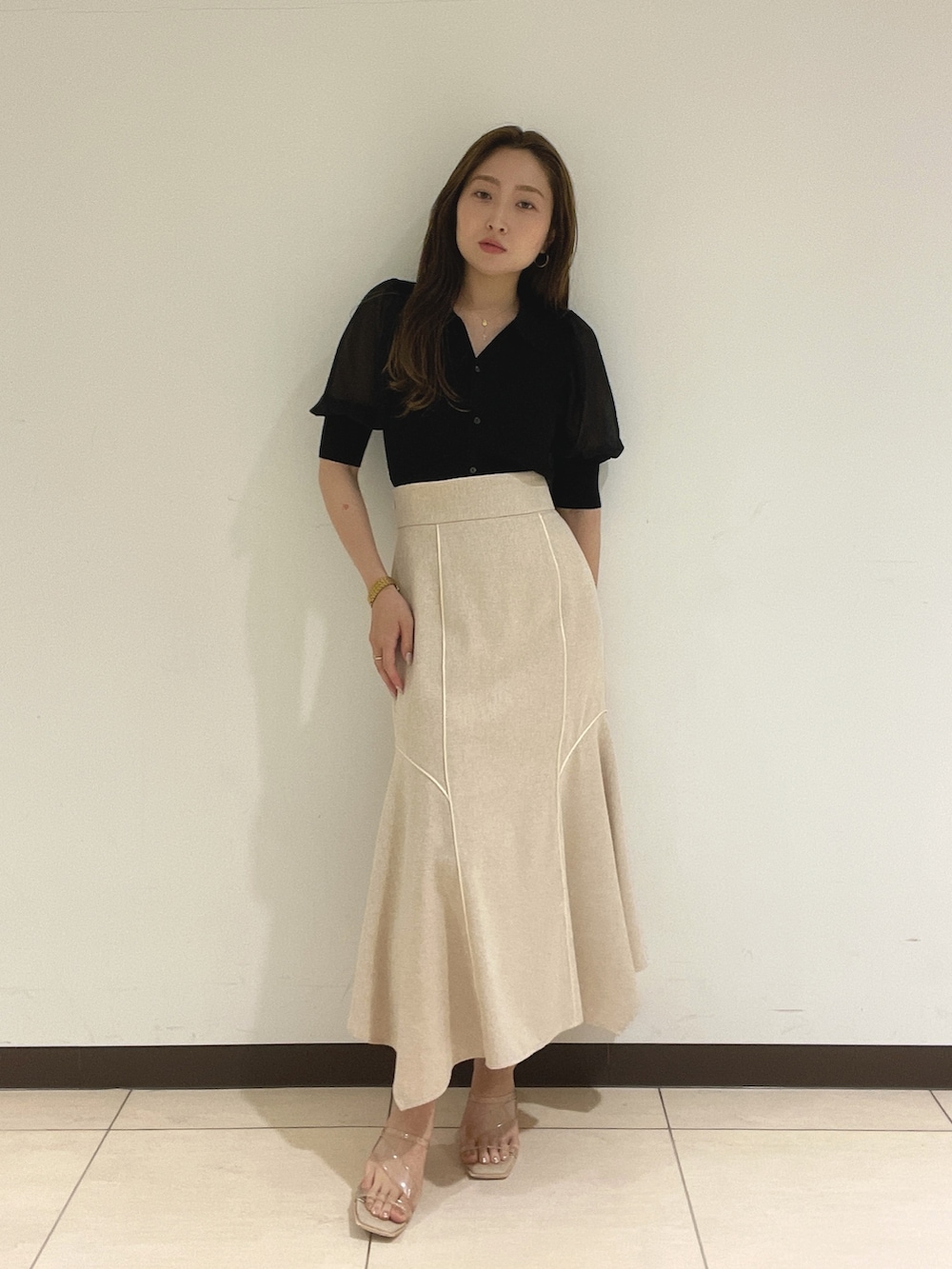 ブラック系のニット/セーター、ホワイト系のスカートを着用したレディースの夏コーディネートの3枚目の写真