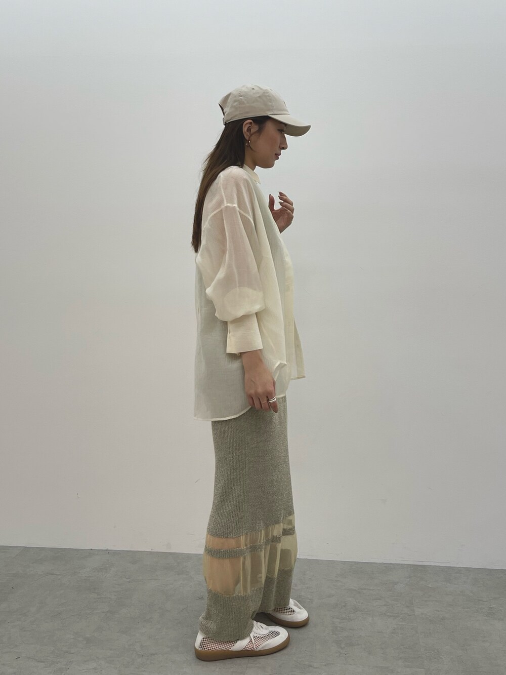 ベージュ系のワンピース、ホワイト系のスニーカー、ホワイト系のシャツ/ブラウスを着用したレディースの春コーディネートの6枚目の写真