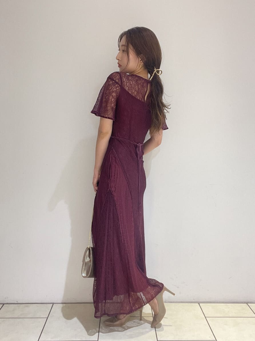 ゴールド系のクラッチバッグ、レッド系のドレス、ゴールド系のパンプスを着用したレディースの夏コーディネートの4枚目の写真