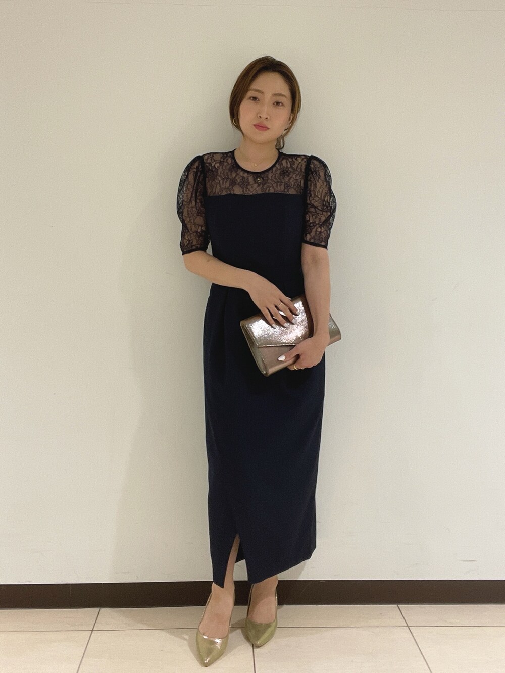 ブルー系のドレス、ゴールド系のハンドバッグ、ゴールド系のパンプスを着用したレディースの夏コーディネートの2枚目の写真