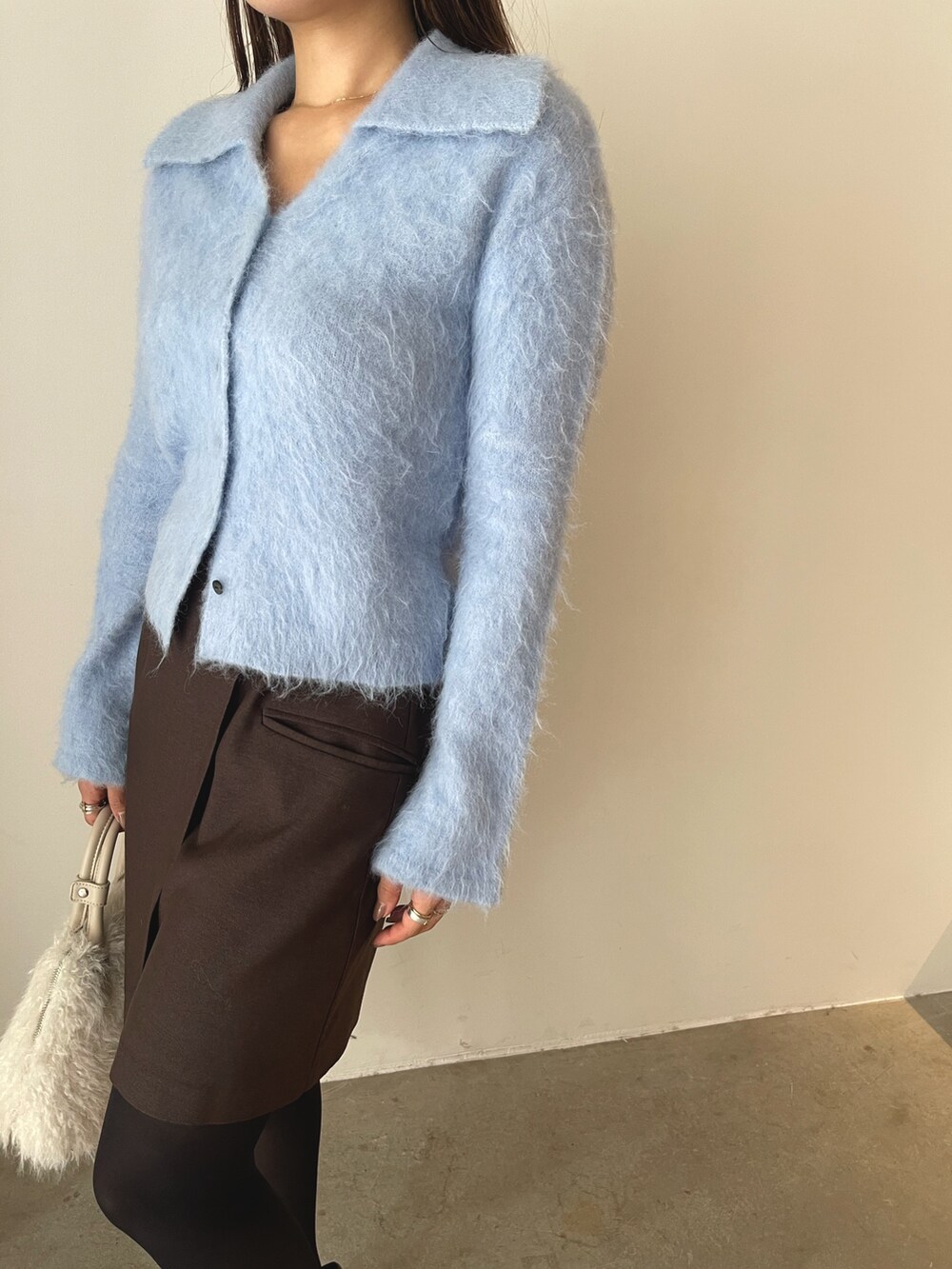 ホワイト系のボストンバッグ、ブラウン系のスカート、ブラック系のローファーを着用したレディースの秋コーディネートの10枚目の写真