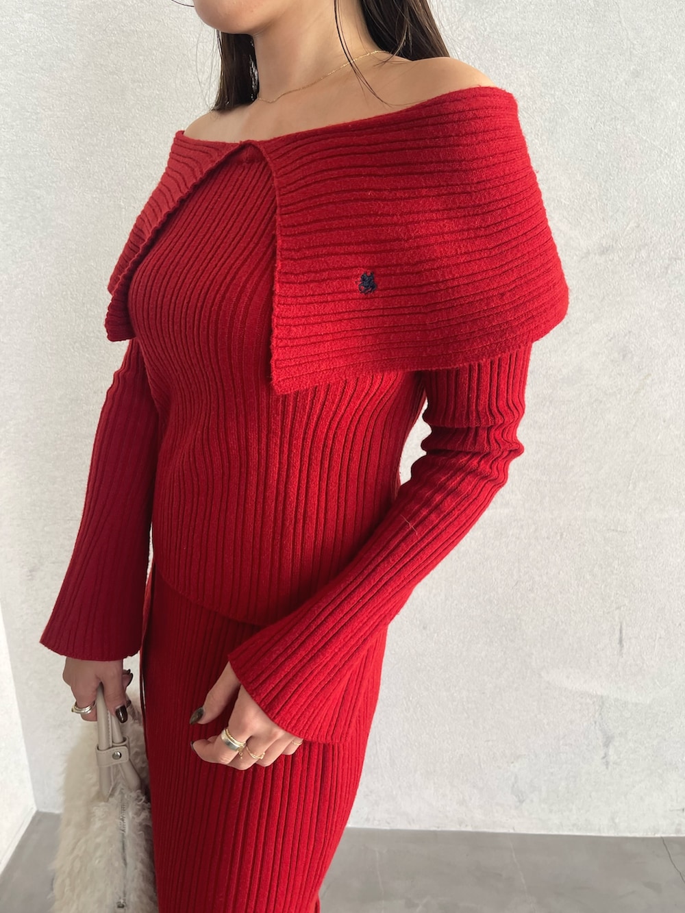 レッド系のニット/セーター、ベージュ系のブーツ、レッド系のスカートを着用したレディースの秋コーディネートの10枚目の写真