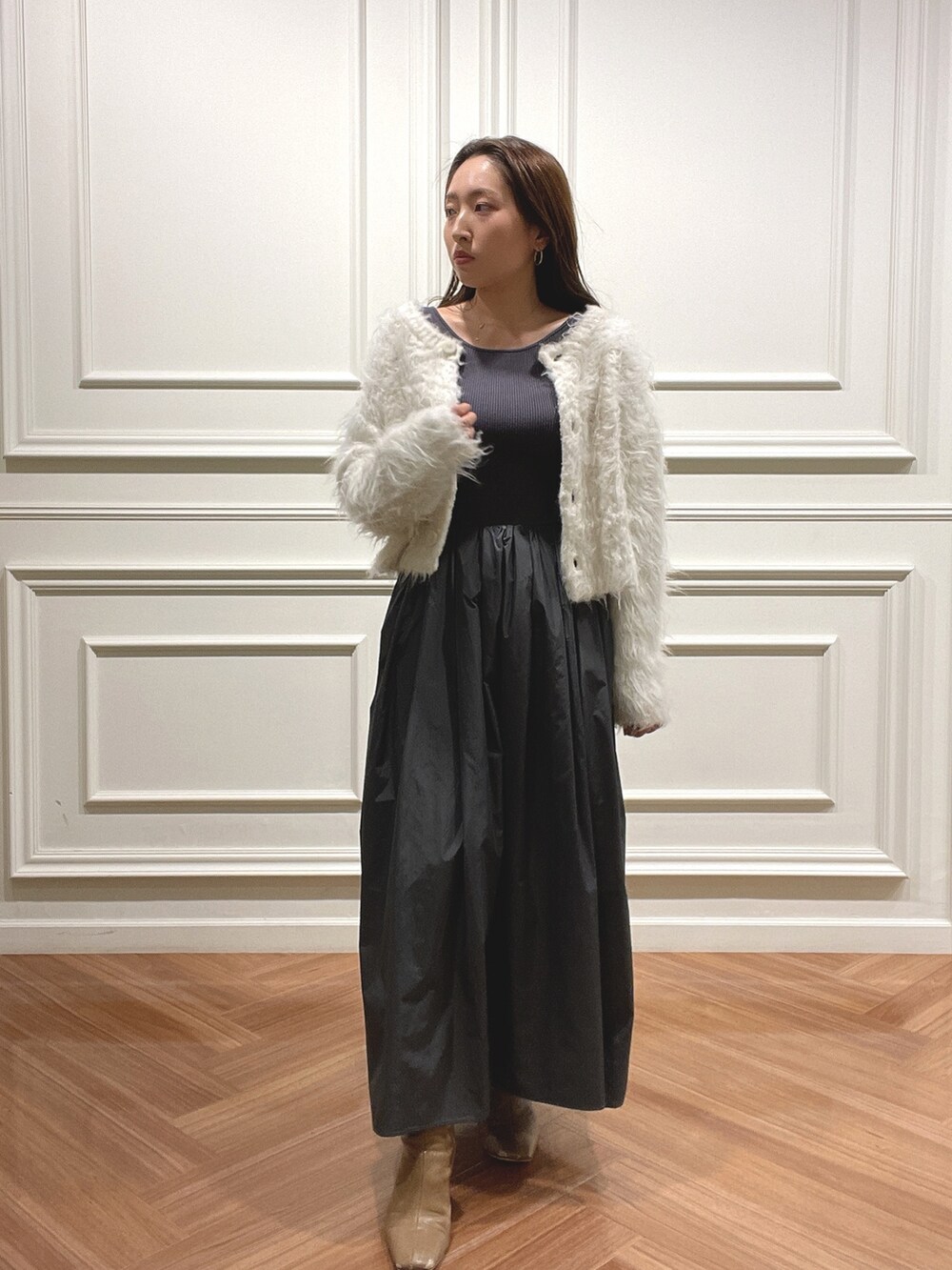 ベージュ系のブーツ、グレー系のワンピース、ホワイト系のカーディガン/ボレロを着用したレディースの秋コーディネートの2枚目の写真