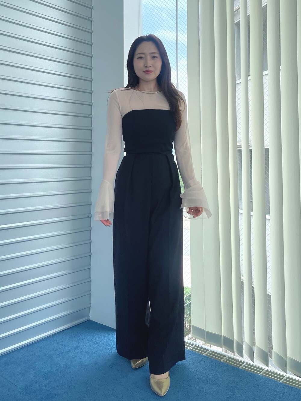 ゴールド系のパンプス、ブラック系のパンツドレス、ホワイト系のTシャツ/カットソーを着用したレディースの夏コーディネートの3枚目の写真
