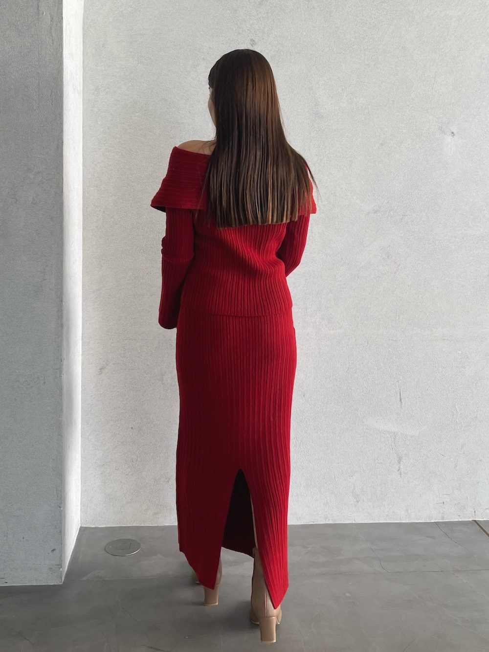 レッド系のニット/セーター、ベージュ系のブーツ、レッド系のスカートを着用したレディースの秋コーディネートの7枚目の写真