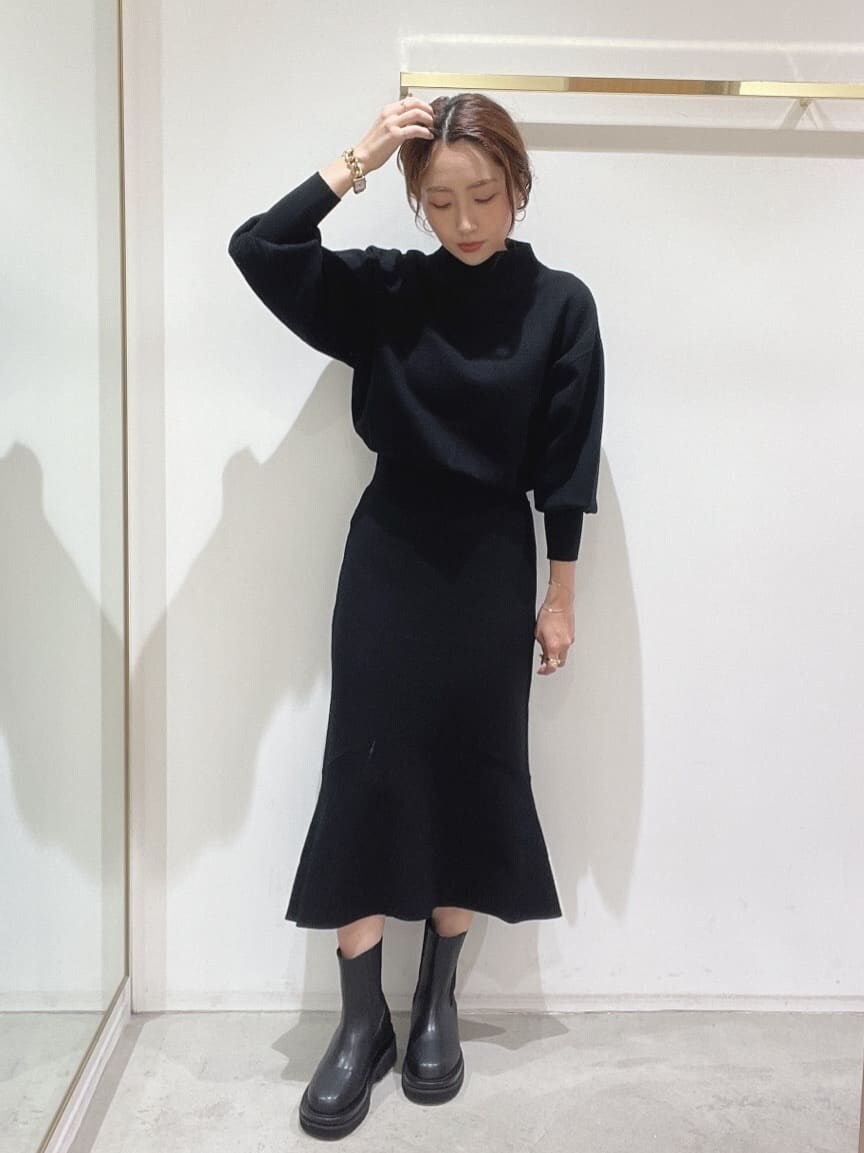 ブラック系のブーツ、ブラック系のニット/セーター、ブラック系のスカートを着用したレディースの秋コーディネートの6枚目の写真