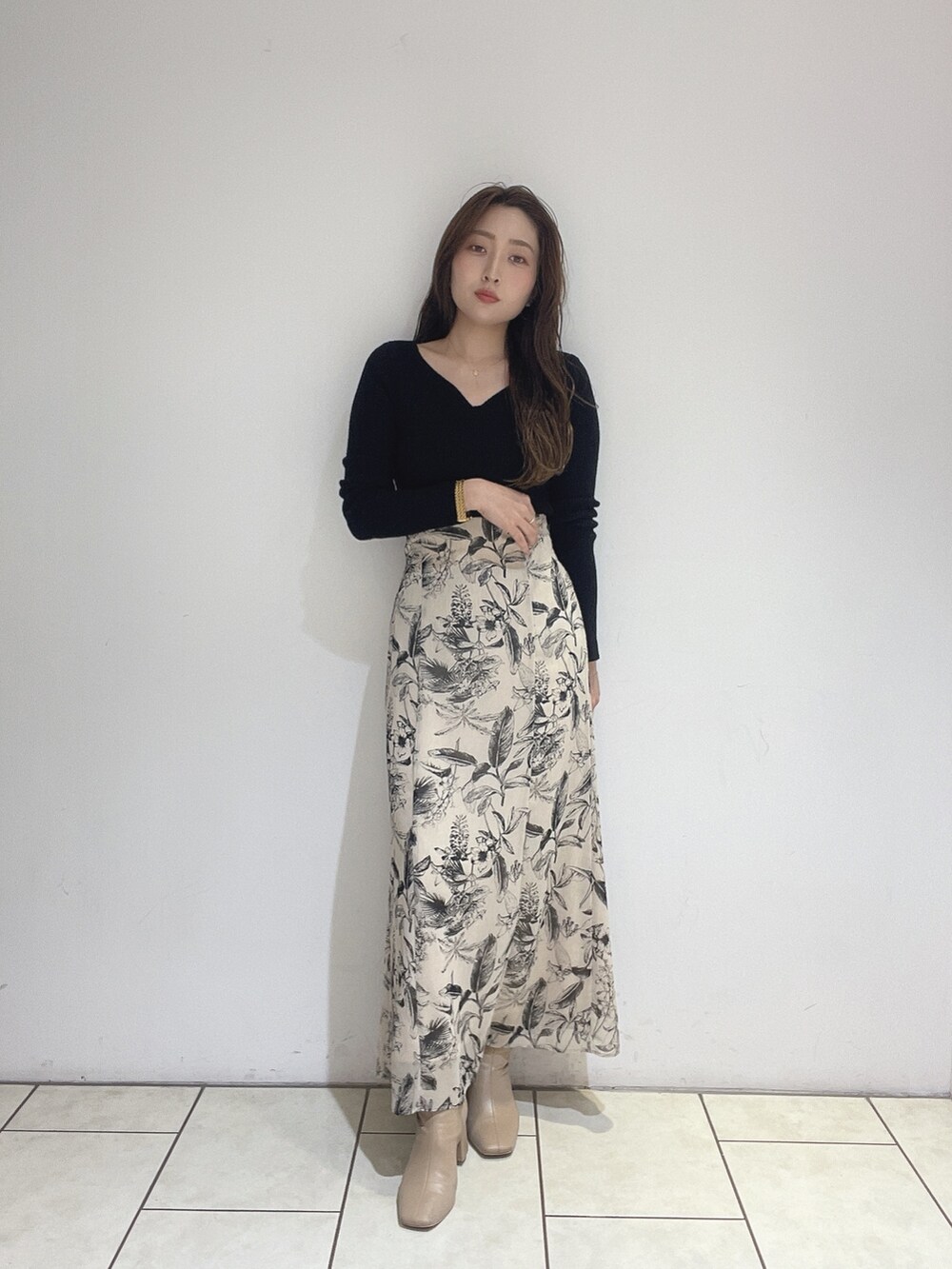 ベージュ系のスカート、ブラック系のニット/セーターを着用したレディースの秋コーディネートの3枚目の写真