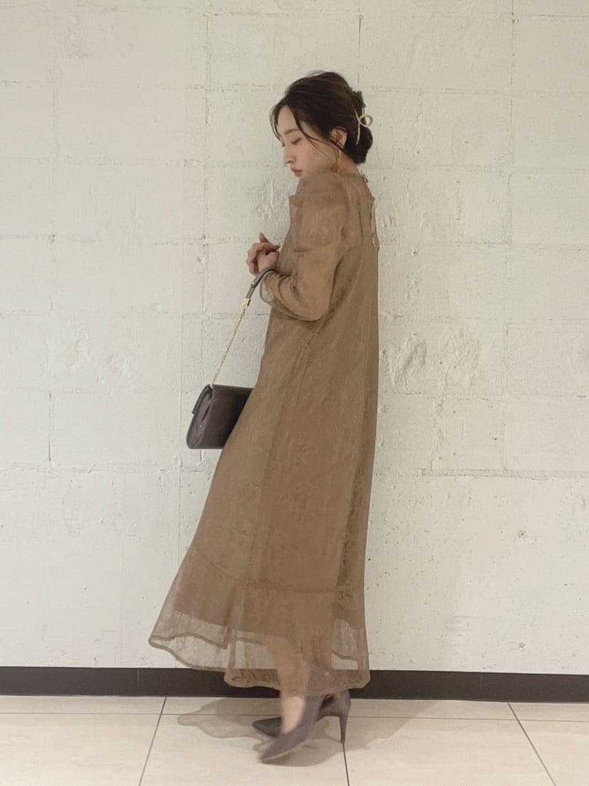 シルバー系のパンプス、シルバー系のハンドバッグ、ベージュ系のドレスを着用したレディースの秋コーディネートの5枚目の写真