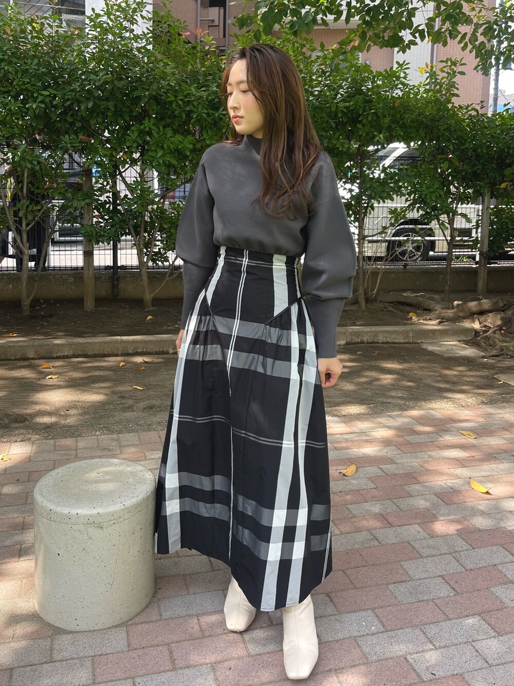 ホワイト系のブーツ、ブラック系のワンピースを着用したレディースの冬コーディネートの3枚目の写真