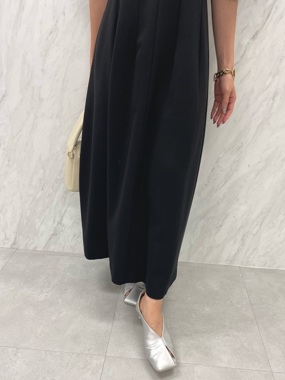 シルバー系のパンプス、ホワイト系のハンドバッグ、ブラック系のパンプスを着用したレディースの冬コーディネートの10枚目の写真