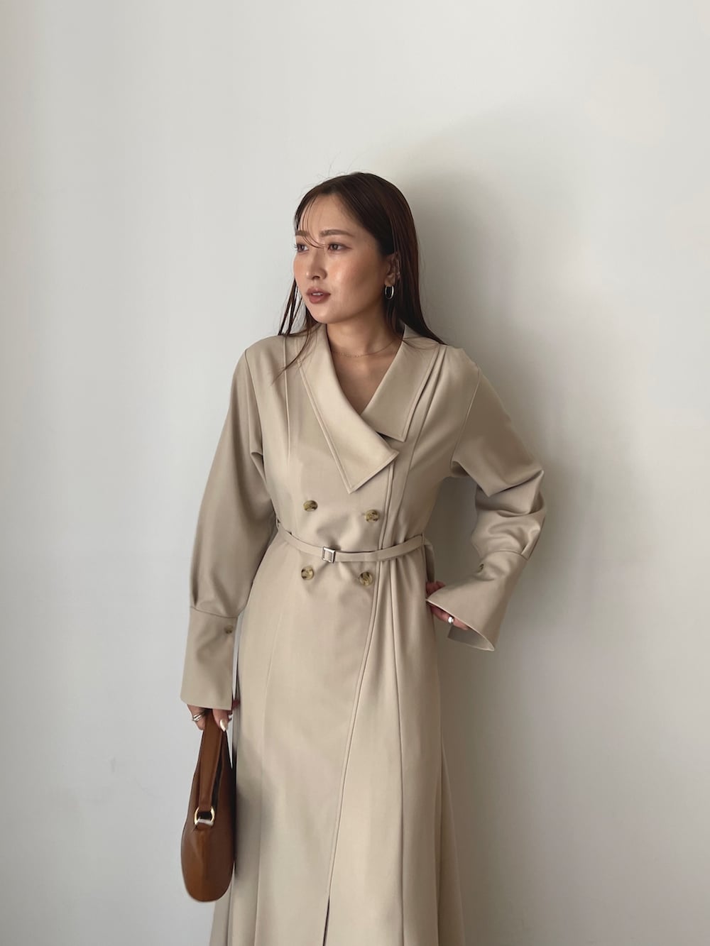 ブラック系のブーツ、ベージュ系のワンピース、イエロー系のハンドバッグを着用したレディースの秋コーディネートの8枚目の写真