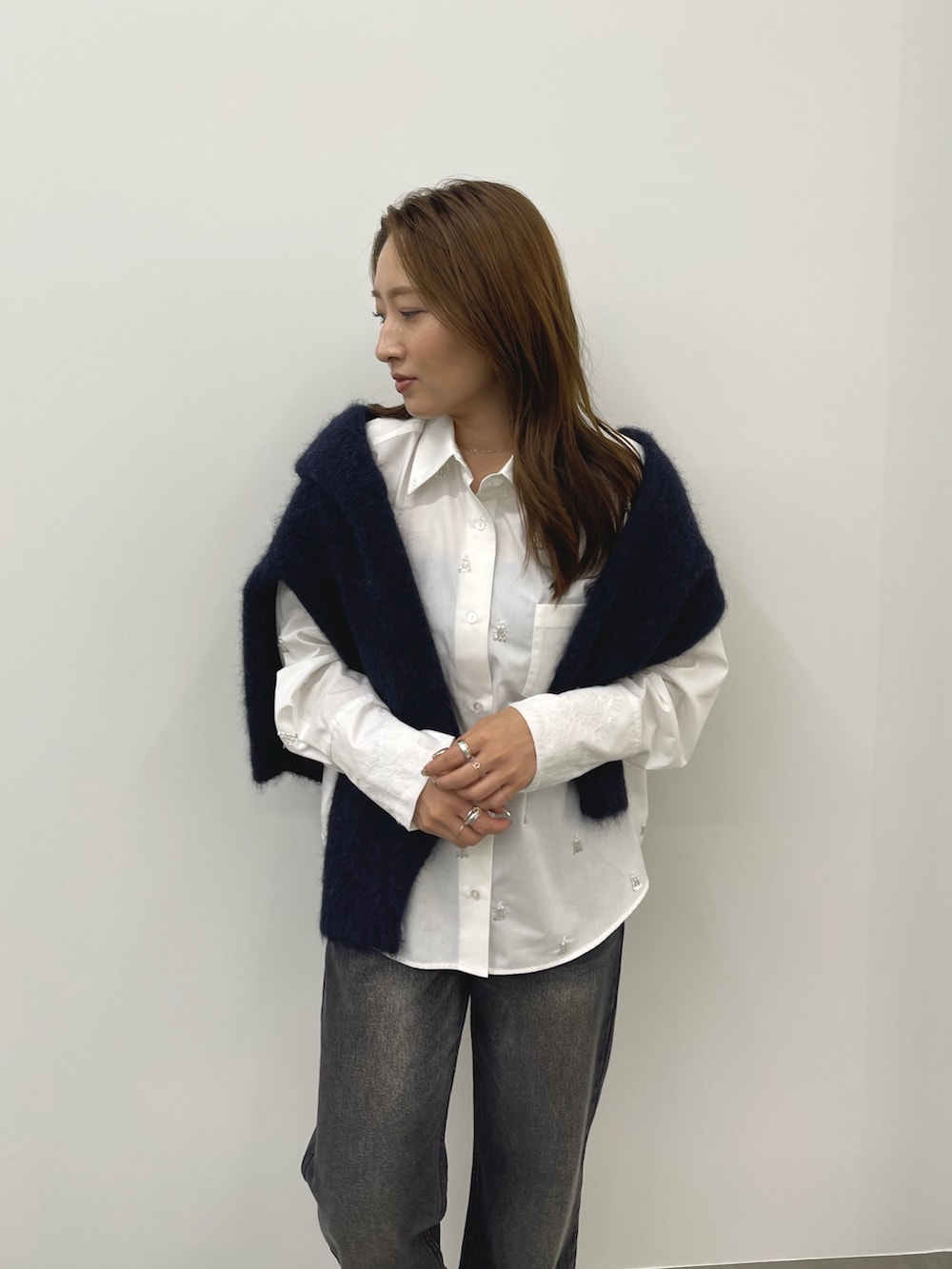 グレー系のデニムパンツ、ホワイト系のシャツ/ブラウス、ブルー系のカーディガン/ボレロを着用したレディースの秋コーディネートの7枚目の写真