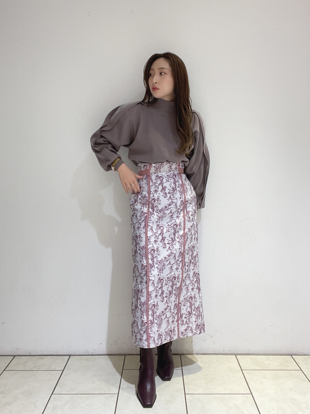 ピンク系のスカート、ブラウン系のニット/セーター、レッド系のブーツを着用したレディースの冬コーディネートの2枚目の写真