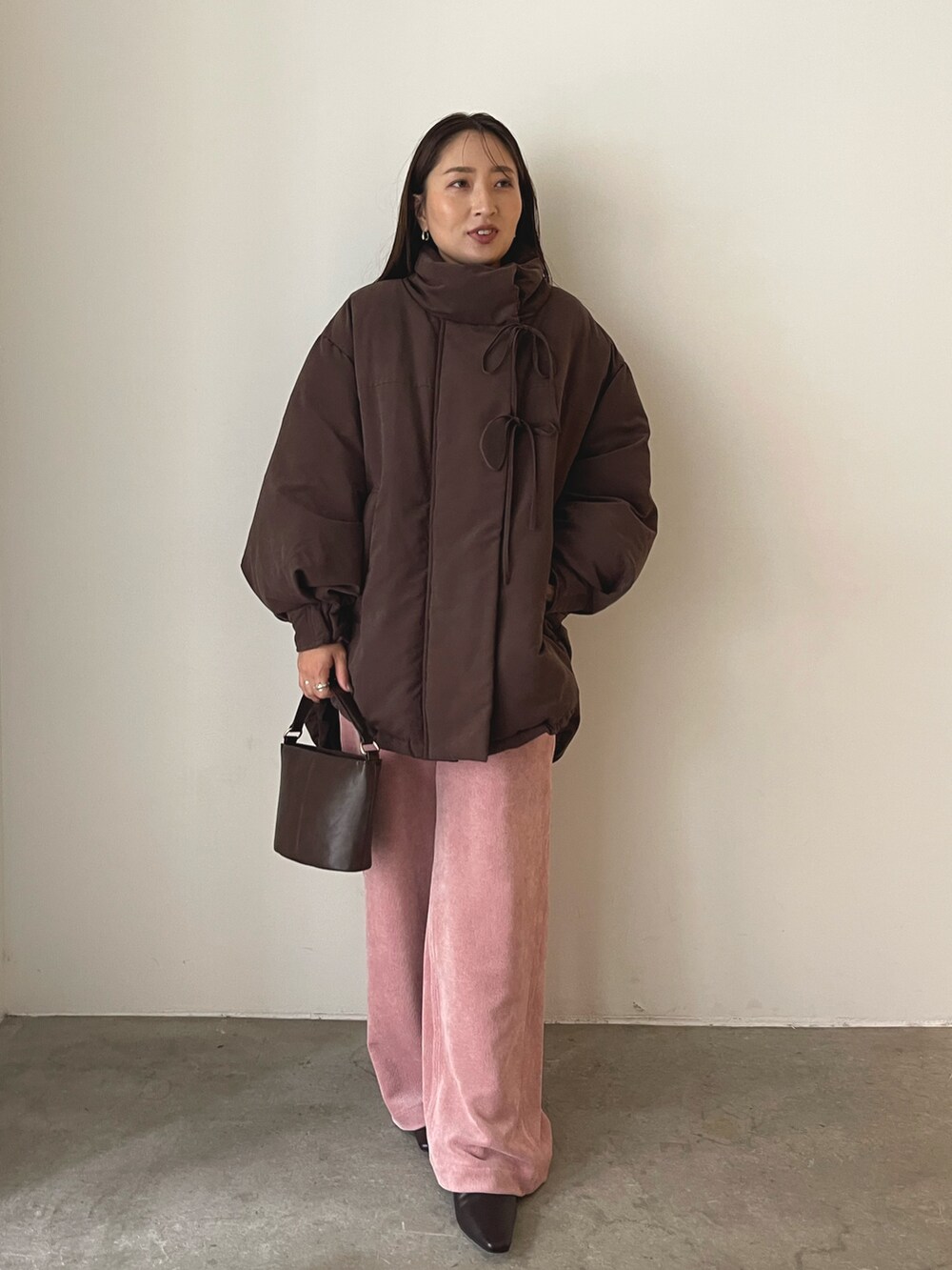 ブラウン系のハンドバッグ、ピンク系のその他パンツ、ブラウン系のブーツを着用したレディースの秋コーディネートの5枚目の写真