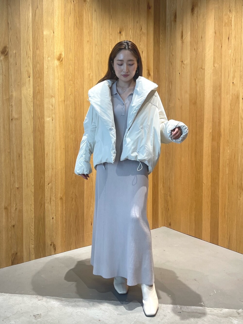 ホワイト系のブーツ、グレー系のワンピース、ホワイト系のダウンジャケット/コートを着用したレディースの秋コーディネートの4枚目の写真