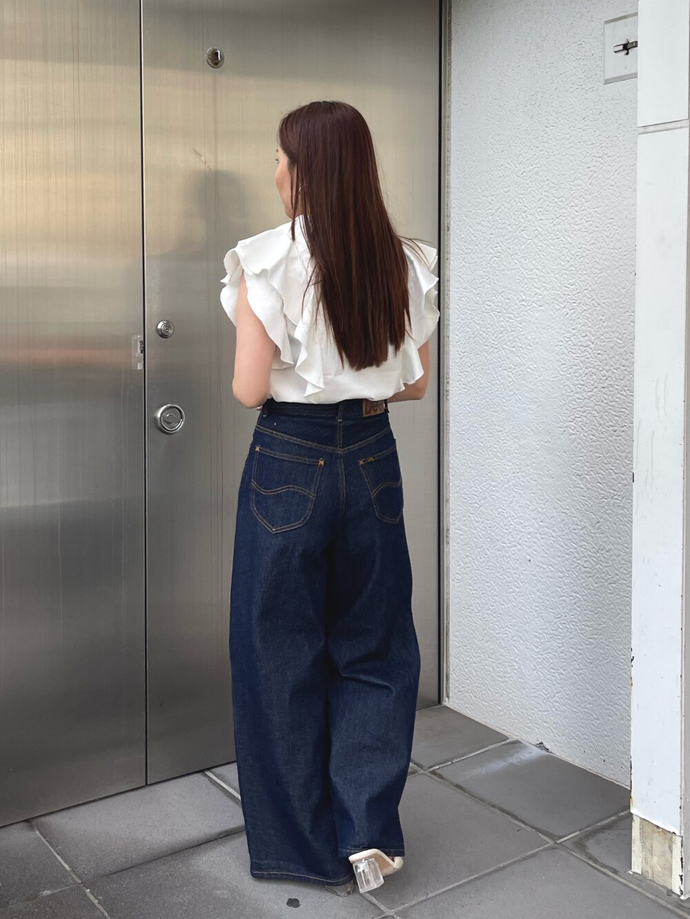 ホワイト系のサンダル、ホワイト系のシャツ/ブラウス、ブルー系のデニムパンツを着用したレディースの春コーディネートの8枚目の写真