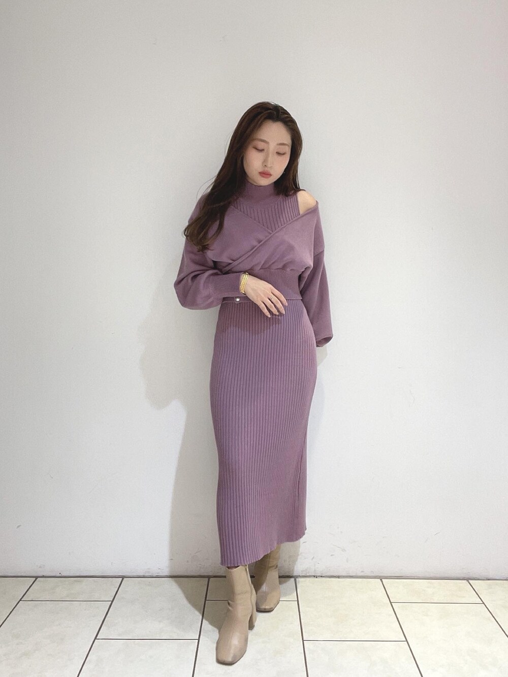 パープル系のワンピース、ベージュ系のブーツを着用したレディースの冬コーディネートの3枚目の写真