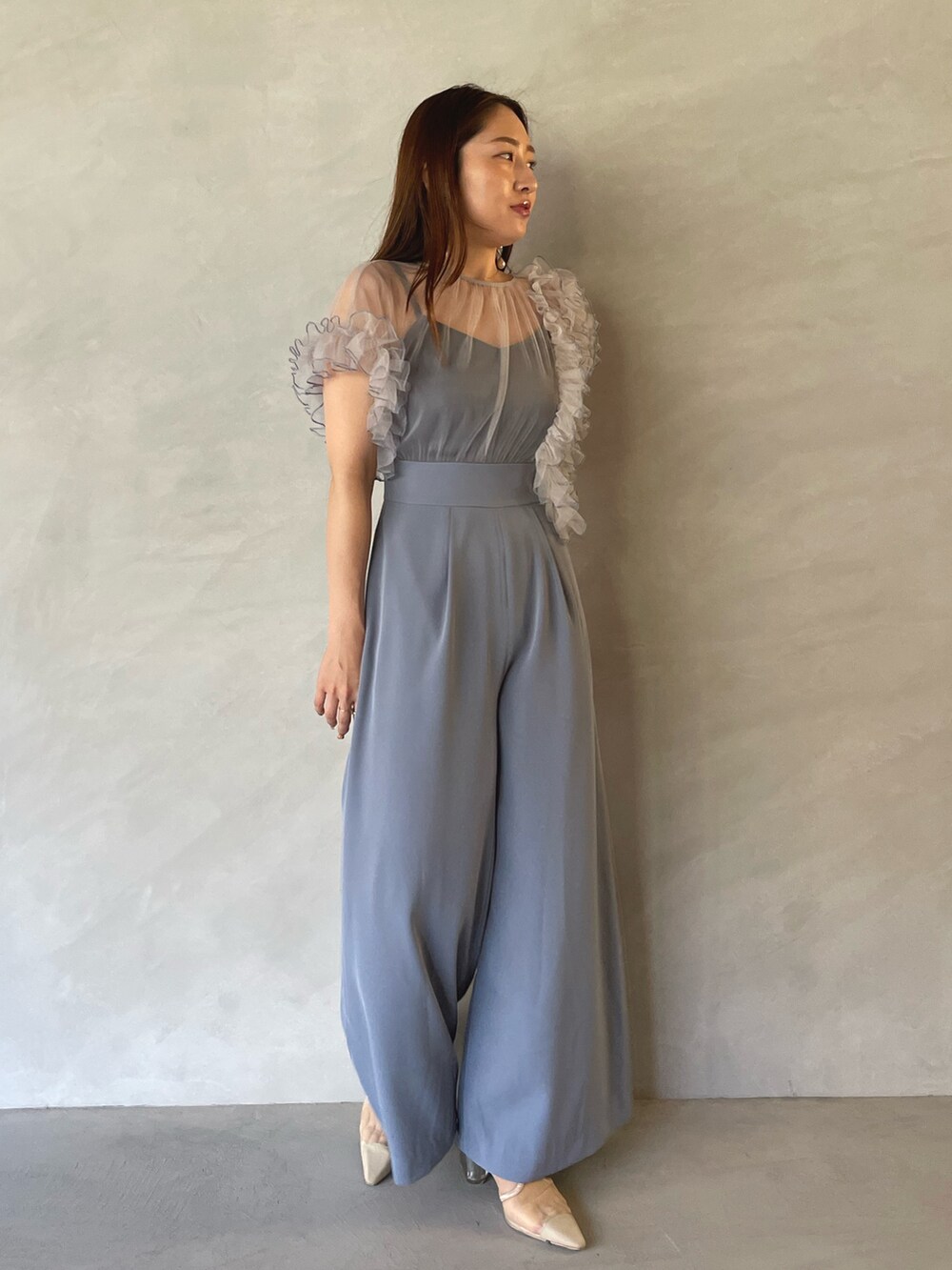 ブルー系のパンツドレス、ゴールド系のピアス（両耳用）を着用したレディースの夏コーディネートの4枚目の写真