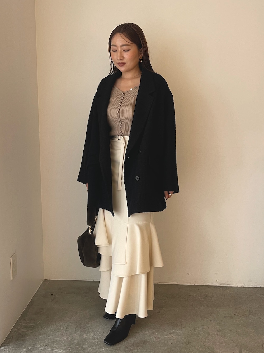 ベージュ系のワンピース、ブラック系のブーツ、ブラウン系のショルダーバッグを着用したレディースの冬コーディネートの5枚目の写真