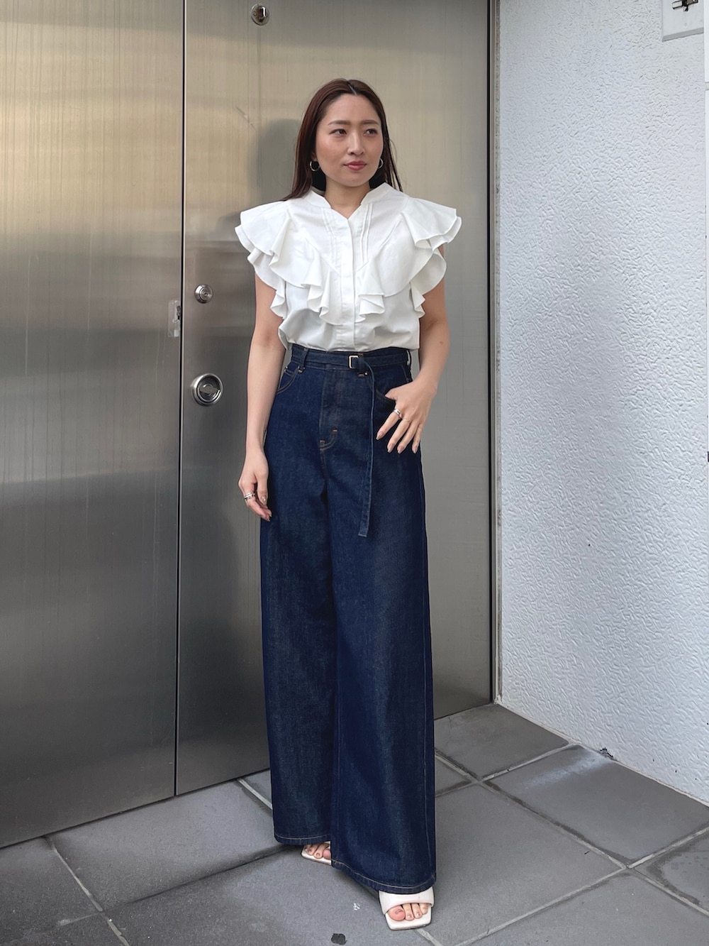 ホワイト系のサンダル、ホワイト系のシャツ/ブラウス、ブルー系のデニムパンツを着用したレディースの春コーディネートの2枚目の写真