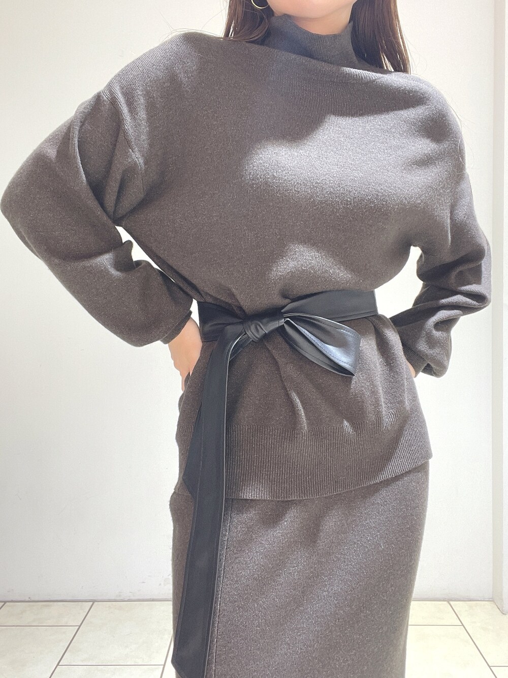 ブラウン系のニット/セーター、ブラウン系のスカート、グリーン系のブーツを着用したレディースの冬コーディネートの9枚目の写真