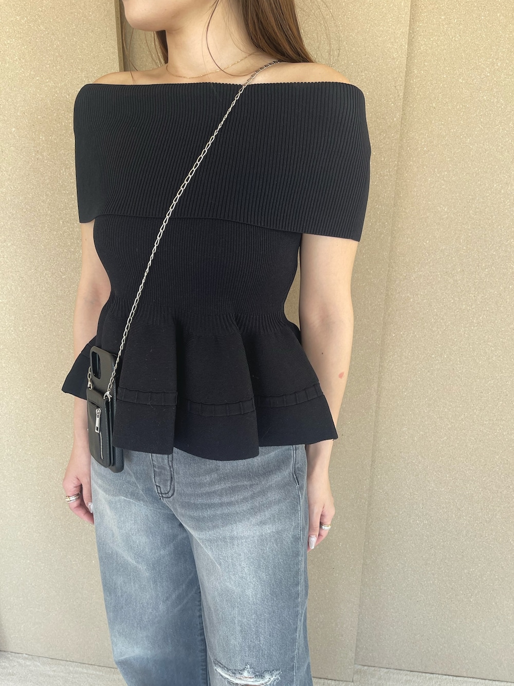 ブラック系のニット/セーター、グレー系のデニムパンツ、オレンジ系のサンダルを着用したレディースの春コーディネートの9枚目の写真