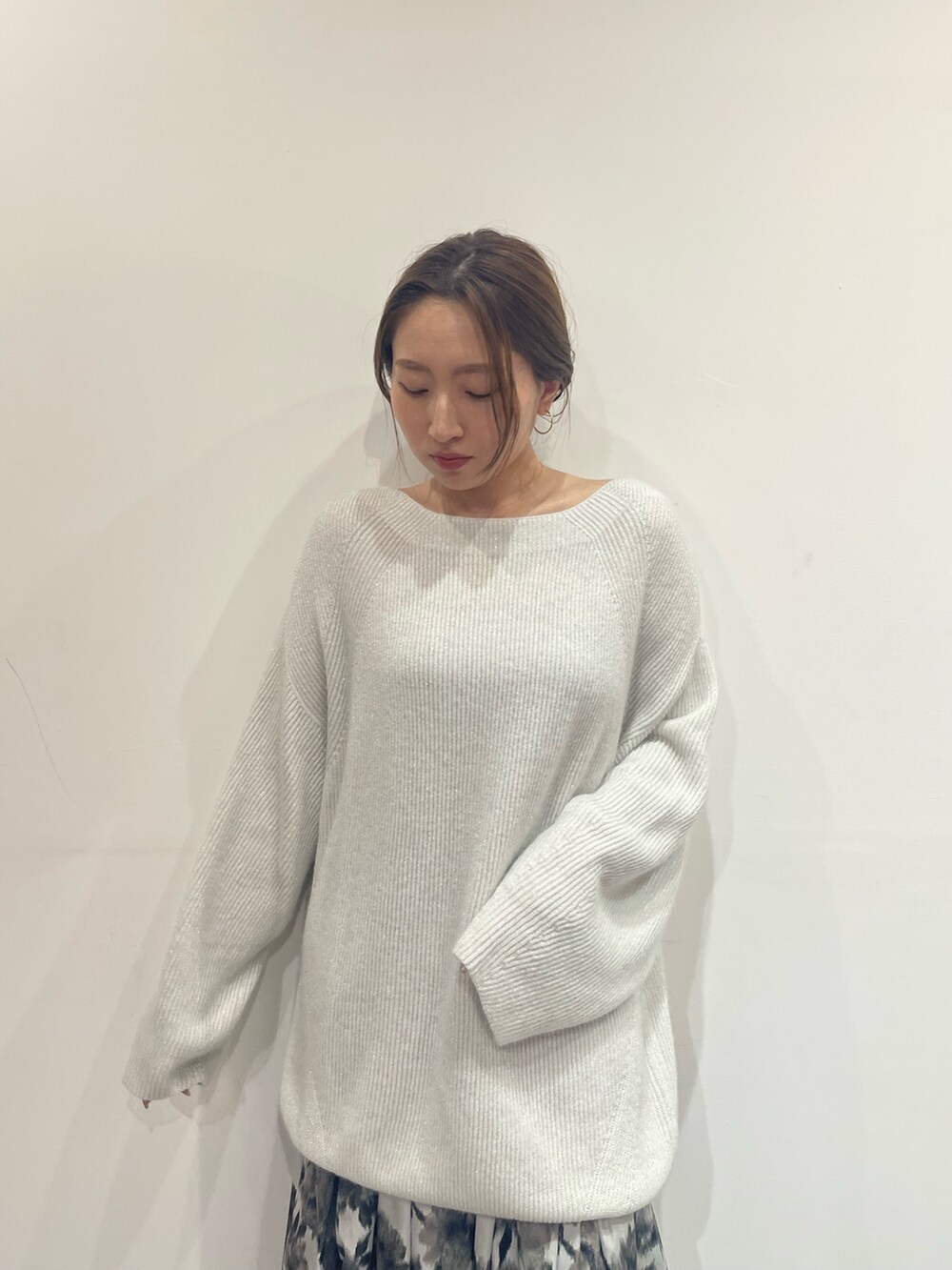 ブラック系のスカート、ブラック系のブーツ、ホワイト系のニット/セーターを着用したレディースの夏コーディネートの5枚目の写真