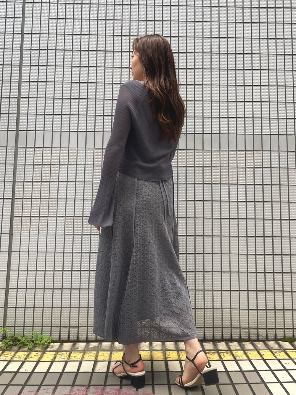 グレー系のワンピース、ブラック系のサンダル、グレー系のカーディガン/ボレロを着用したレディースの春コーディネートの5枚目の写真