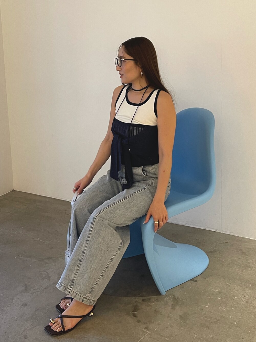 ブルー系のデニムパンツ、シルバー系のハンドバッグ、ブラウン系のサンダルを着用したレディースの春コーディネートの6枚目の写真