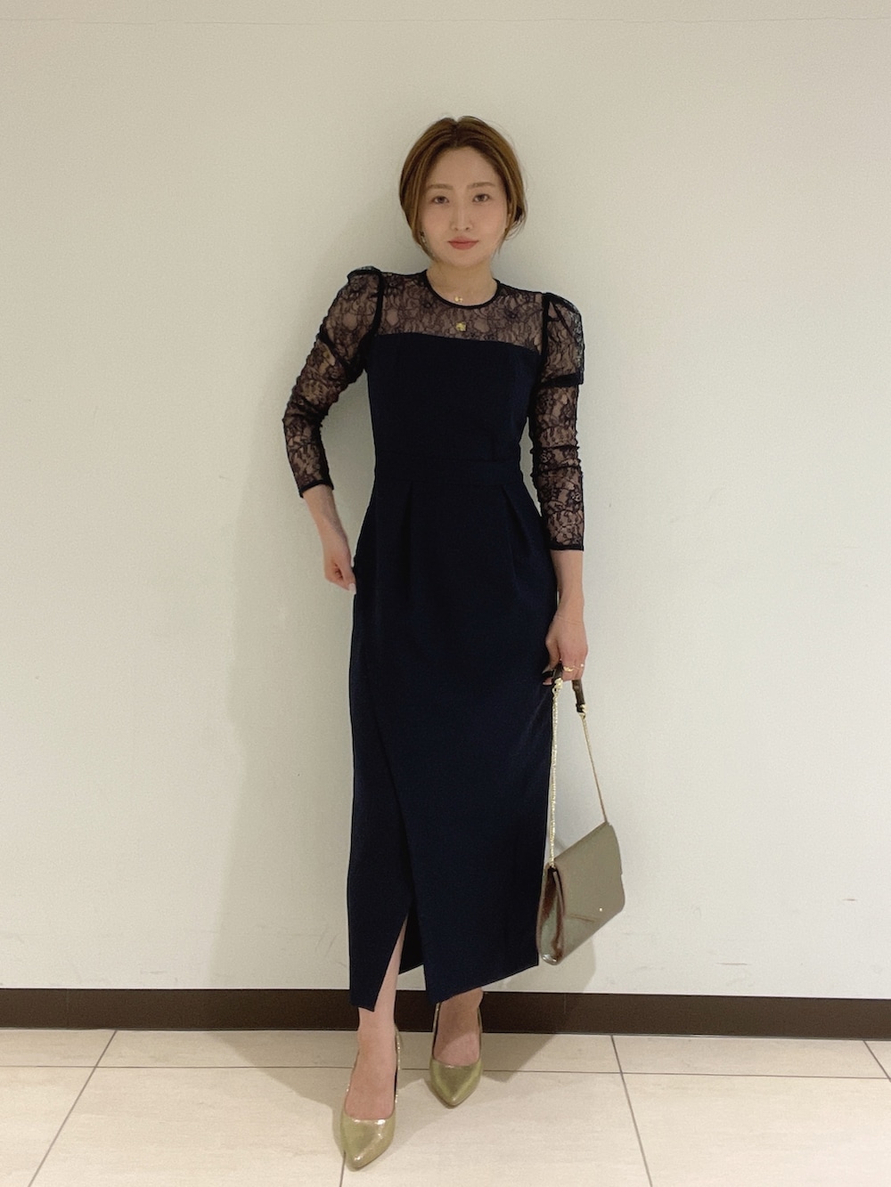 ゴールド系のハンドバッグ、ゴールド系のパンプス、ブルー系のドレスを着用したレディースの夏コーディネートの4枚目の写真