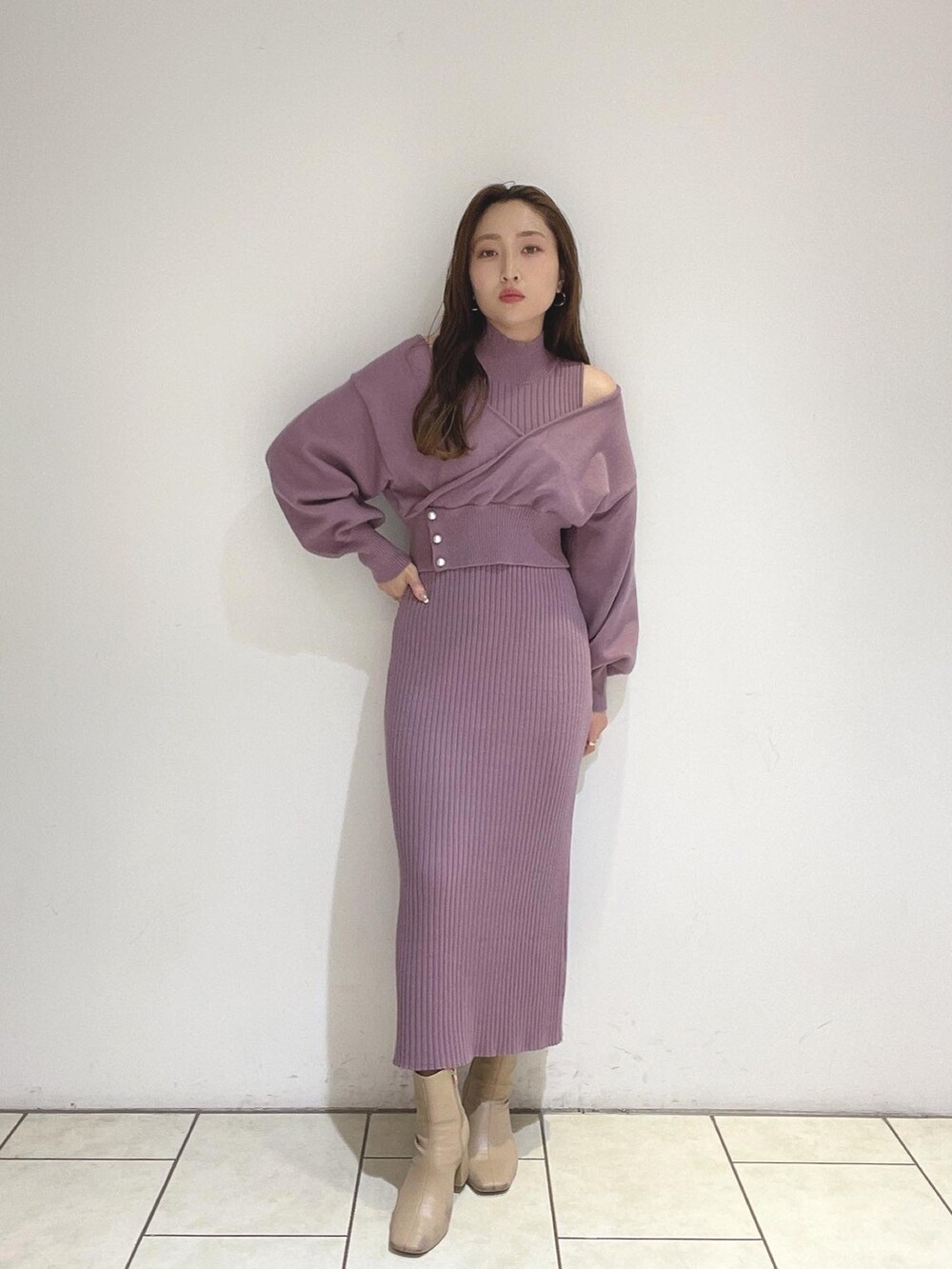 パープル系のワンピース、ベージュ系のブーツを着用したレディースの冬コーディネートの2枚目の写真