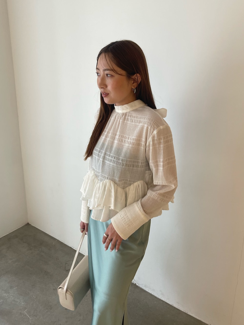 シルバー系のパンプス、ホワイト系のシャツ/ブラウス、グリーン系のスカートを着用したレディースの冬コーディネートの8枚目の写真