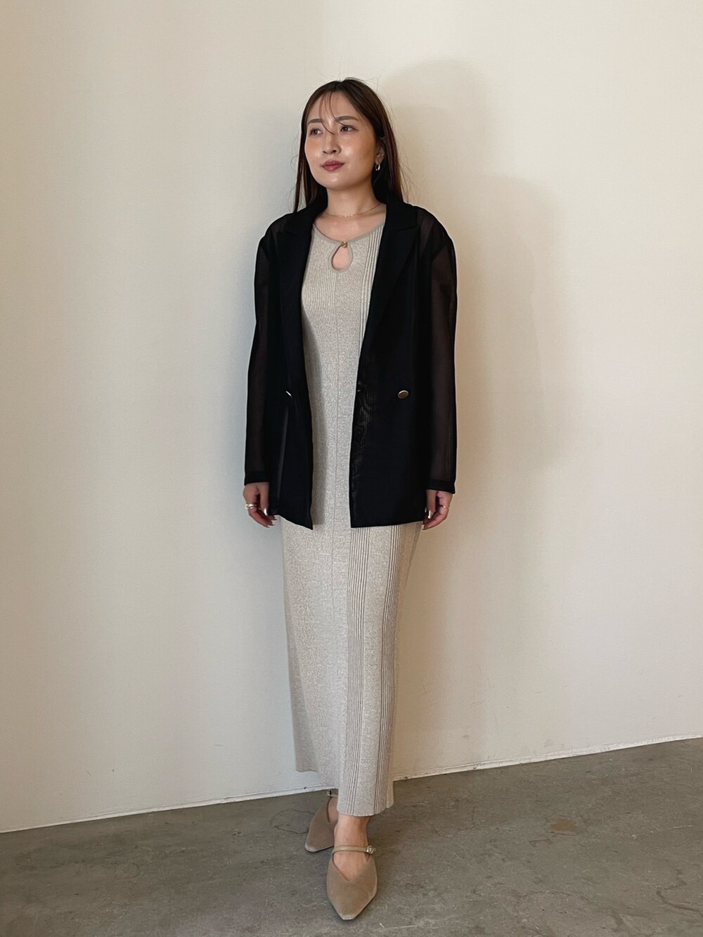 ベージュ系のワンピース、ブラック系のテーラードジャケット、ベージュ系のパンプスを着用したレディースの夏コーディネートの3枚目の写真