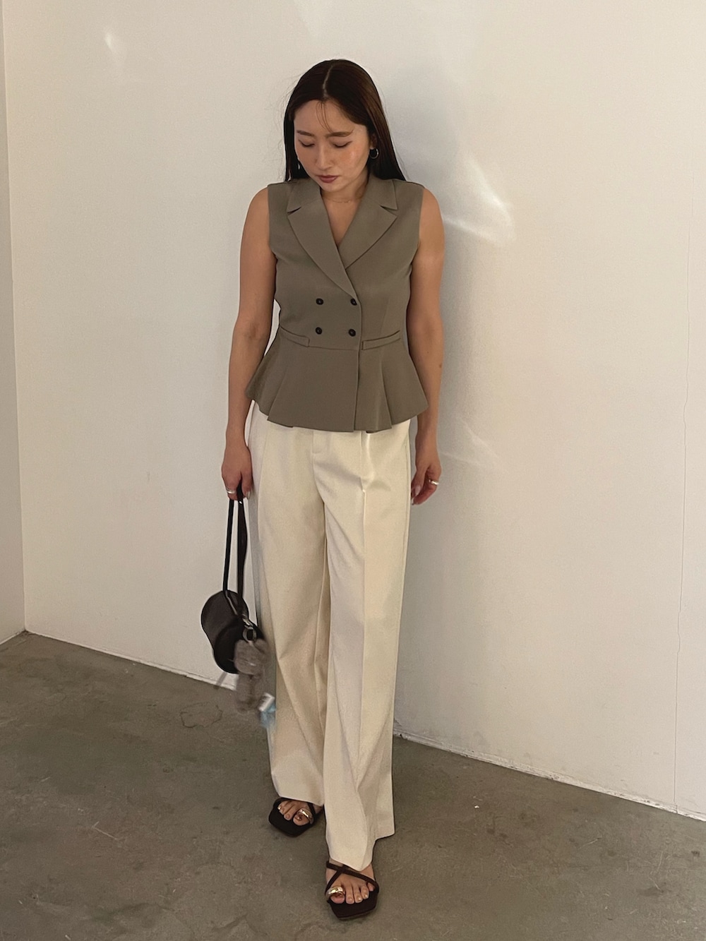 ブラウン系のサンダル、ブラウン系のベスト、ホワイト系のその他パンツを着用したレディースの春コーディネートの3枚目の写真
