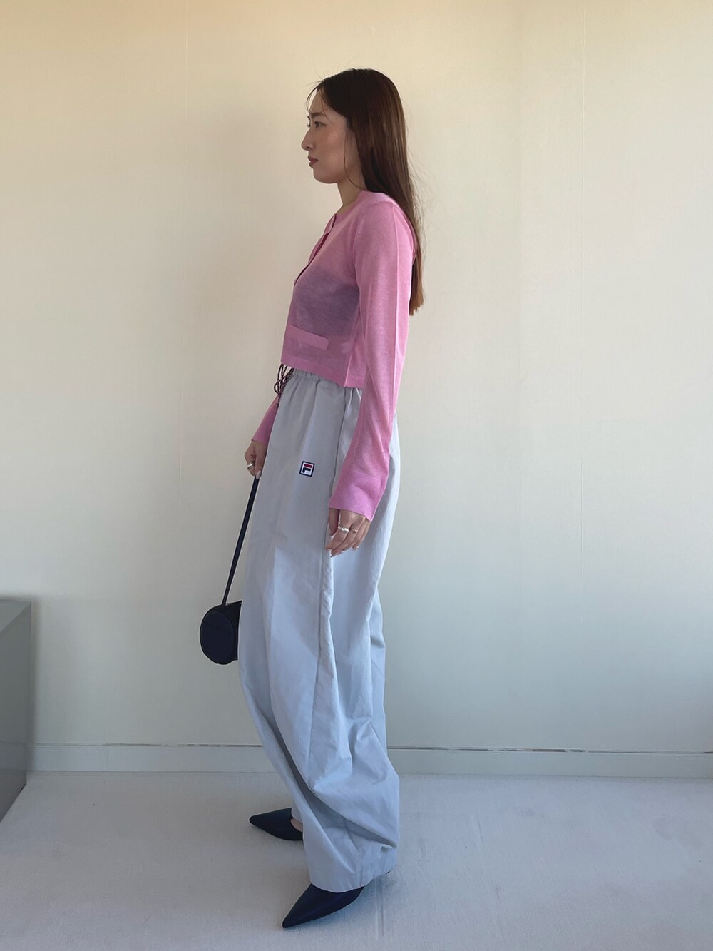 ピンク系のカーディガン/ボレロ、ベージュ系のその他パンツ、ブラック系のパンプスを着用したレディースの冬コーディネートの5枚目の写真