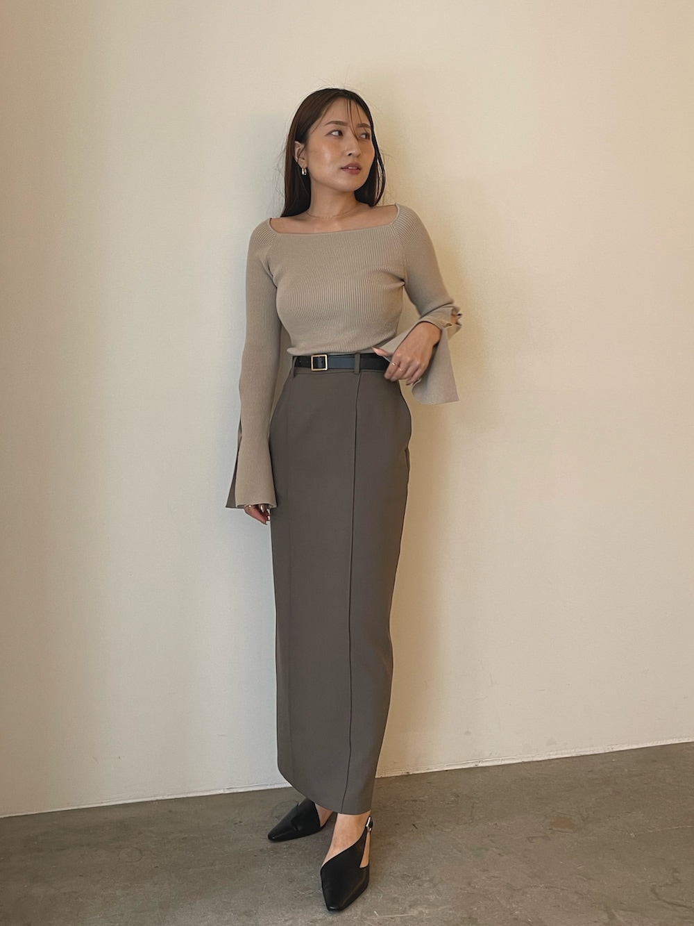 ブラック系のパンプス、グレー系のスカート、ベージュ系のニット/セーターを着用したレディースの秋コーディネートの9枚目の写真
