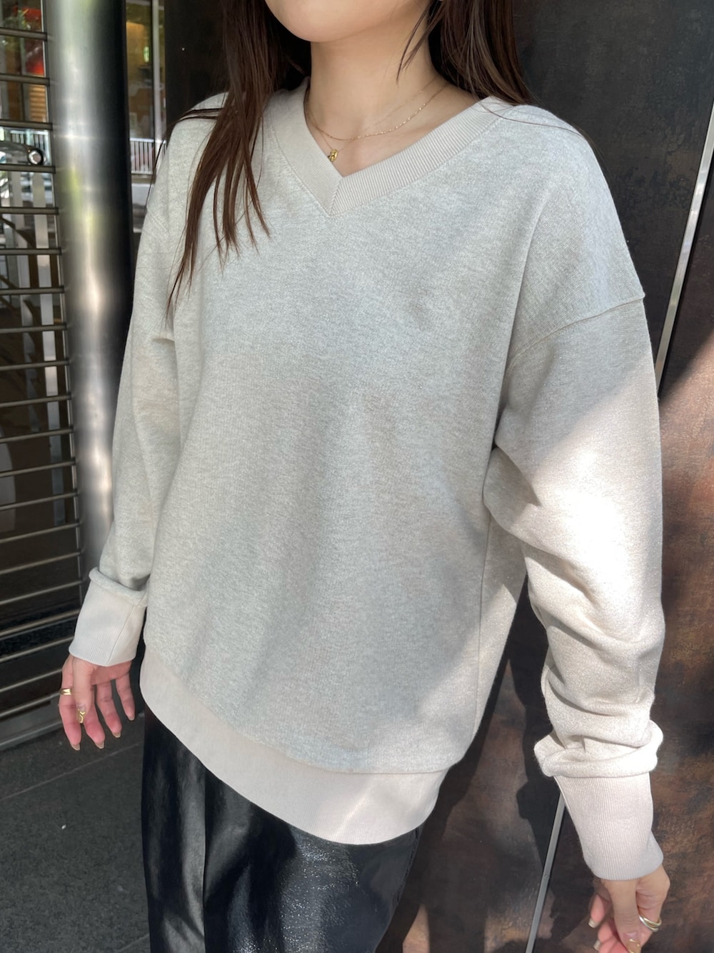 ブラック系のブーツ、ブラック系のスカート、ベージュ系のスウェットを着用したレディースの夏コーディネートの6枚目の写真