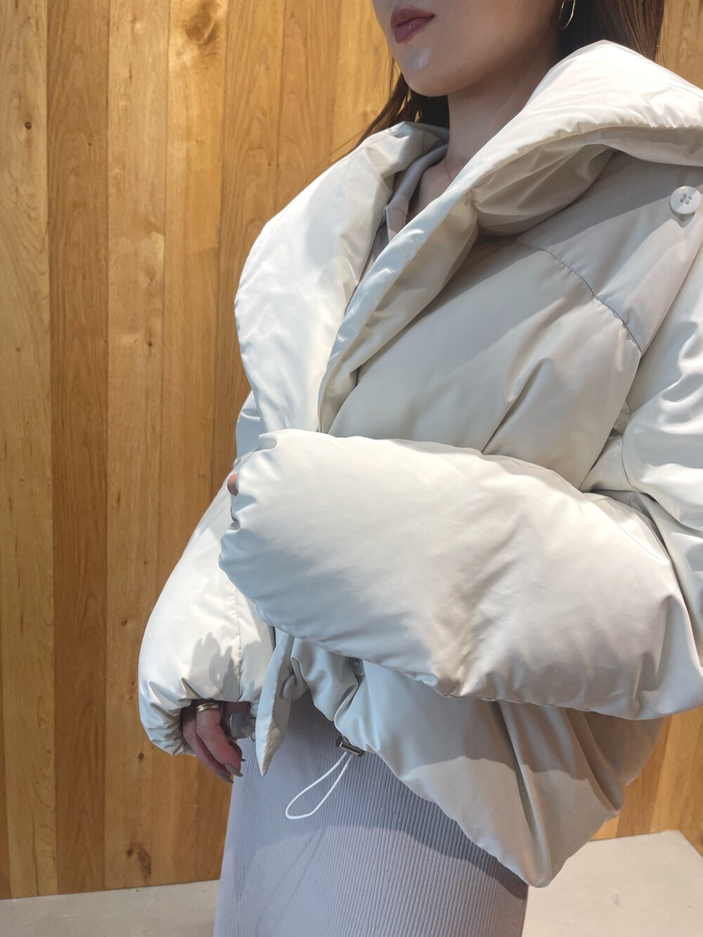 ホワイト系のブーツ、グレー系のワンピース、ホワイト系のダウンジャケット/コートを着用したレディースの秋コーディネートの8枚目の写真