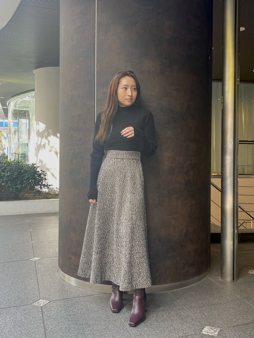 ブラック系のスカート、レッド系のブーツを着用したレディースの秋コーディネートの2枚目の写真