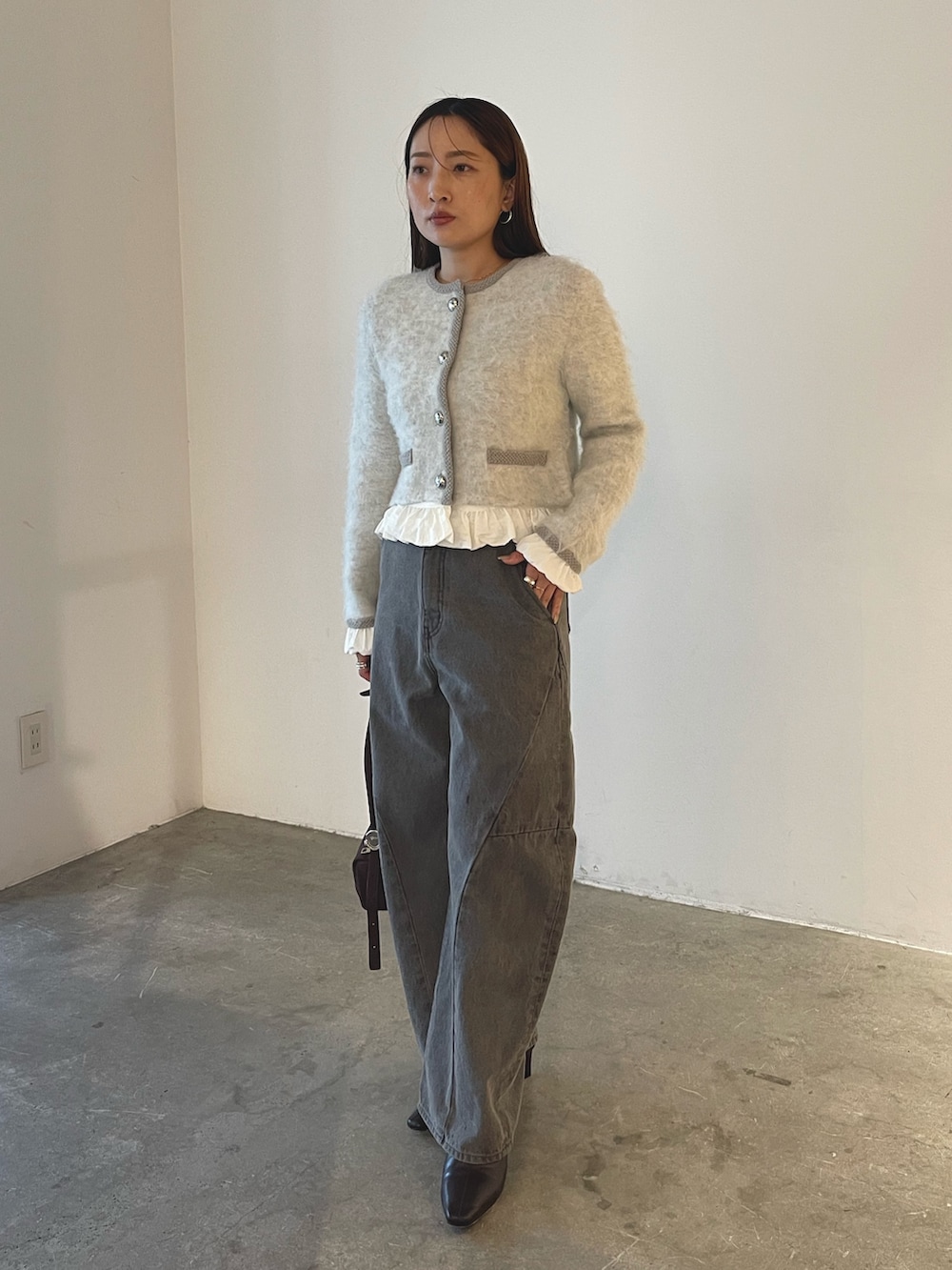 ブラウン系のハンドバッグ、グレー系のデニムパンツ、グレー系のノーカラージャケットを着用したレディースの秋コーディネートの6枚目の写真