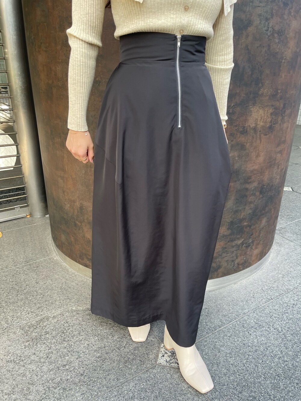 ホワイト系のブーツ、ベージュ系のニット/セーター、ブラック系のスカートを着用したレディースの冬コーディネートの7枚目の写真