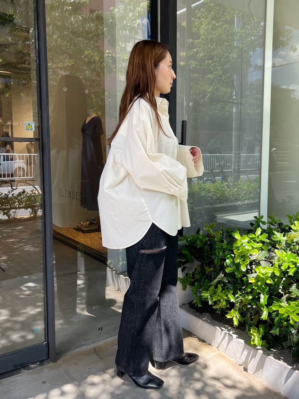 ホワイト系のシャツ/ブラウス、ブラック系のブーツ、ブラック系のデニムパンツを着用したレディースの秋コーディネートの3枚目の写真