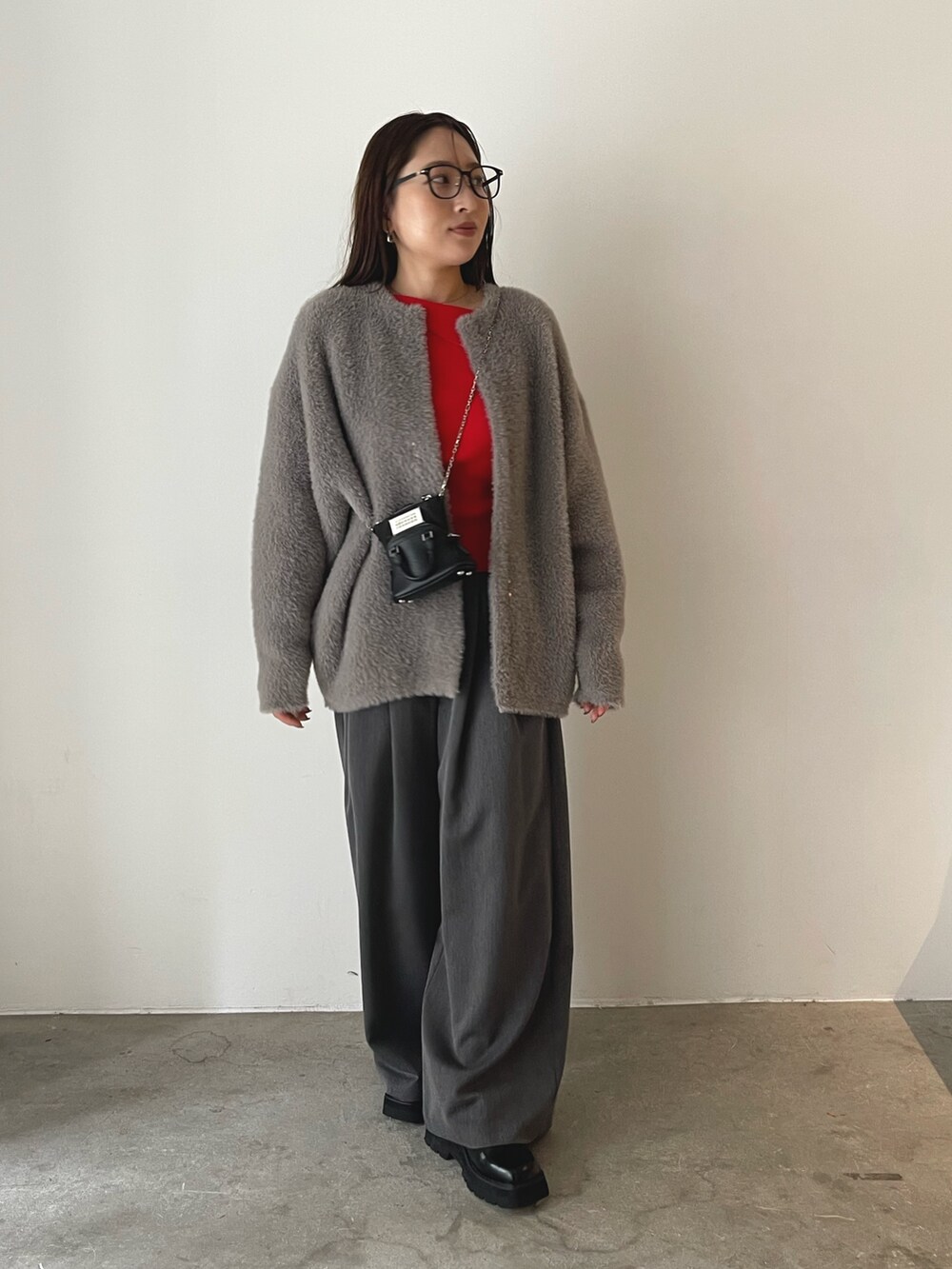 ブラック系のローファー、グレー系のその他パンツ、レッド系のニット/セーターを着用したレディースの秋コーディネートの5枚目の写真