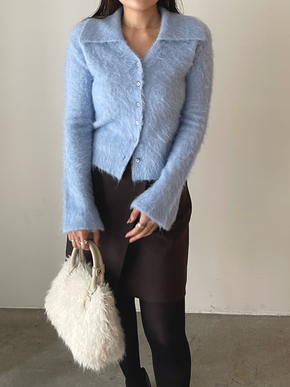 ホワイト系のボストンバッグ、ブラウン系のスカート、ブラック系のローファーを着用したレディースの秋コーディネートの8枚目の写真