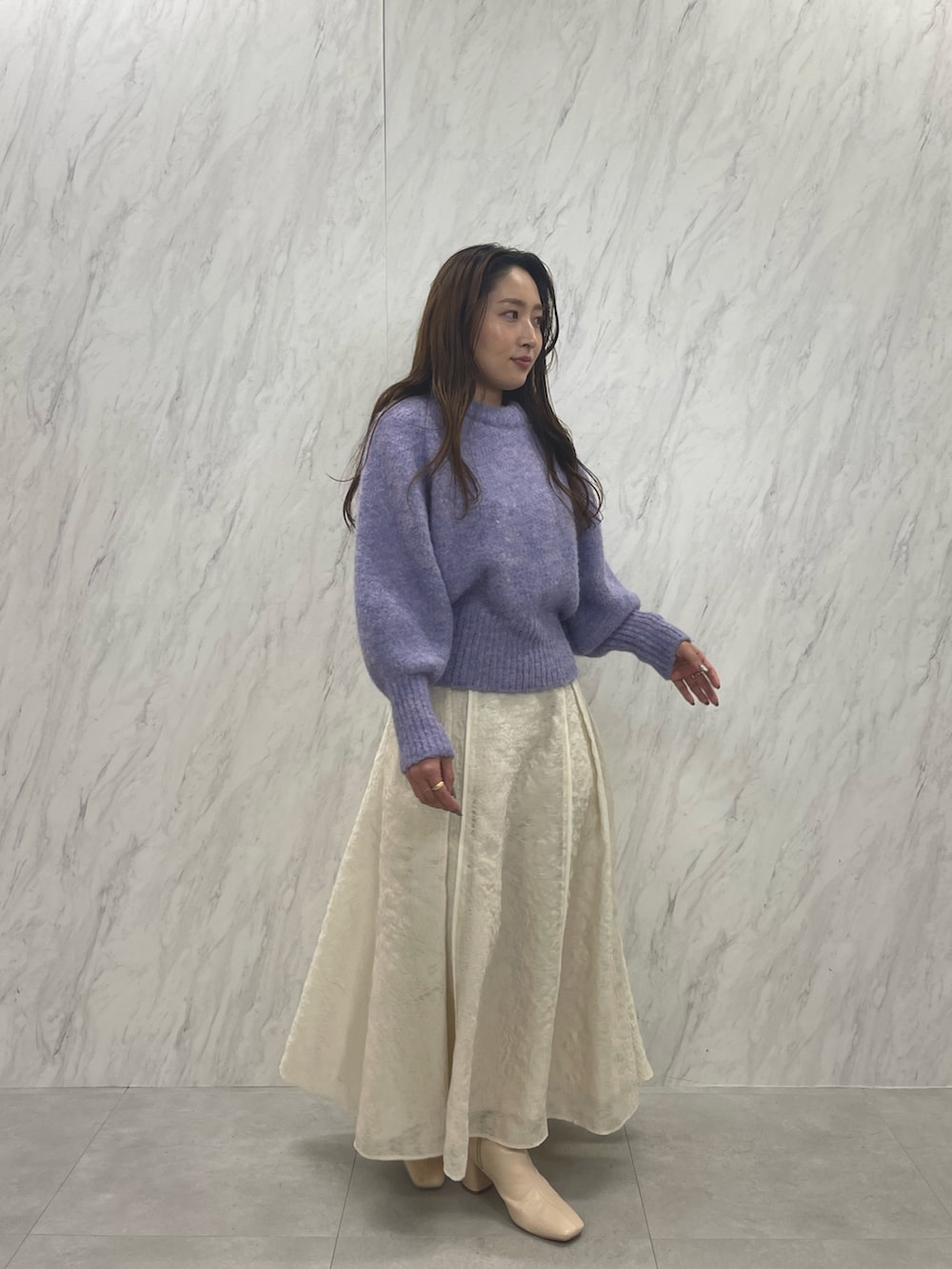 ホワイト系のスカート、ホワイト系のブーツ、パープル系のニット/セーターを着用したレディースの冬コーディネートの3枚目の写真