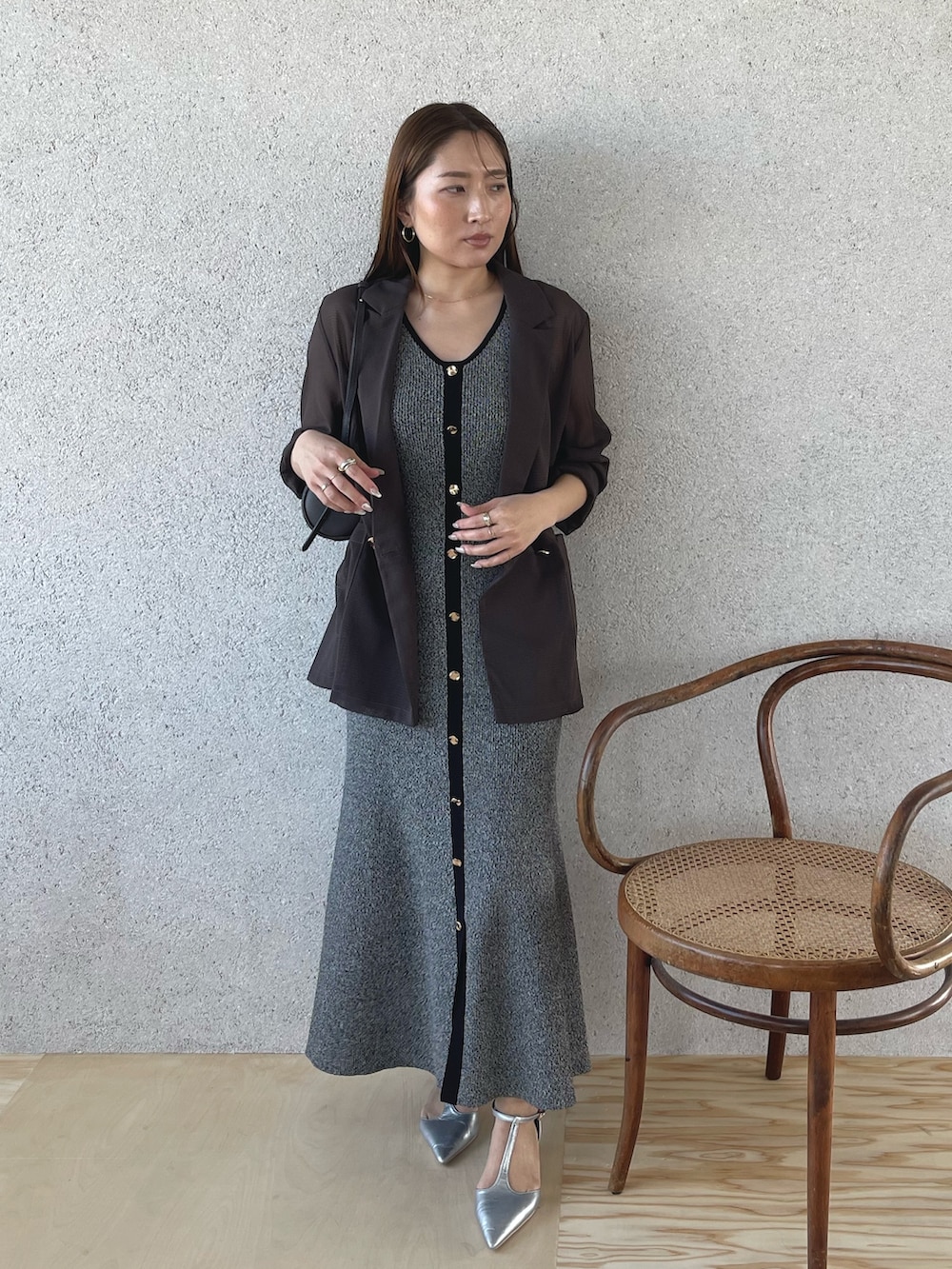 シルバー系のパンプス、ブラック系のワンピース、ブラウン系のテーラードジャケットを着用したレディースの春コーディネートの2枚目の写真