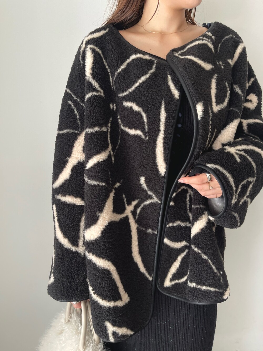 ブラック系のブーツ、ホワイト系のボストンバッグ、ブラック系のブルゾンを着用したレディースの秋コーディネートの8枚目の写真