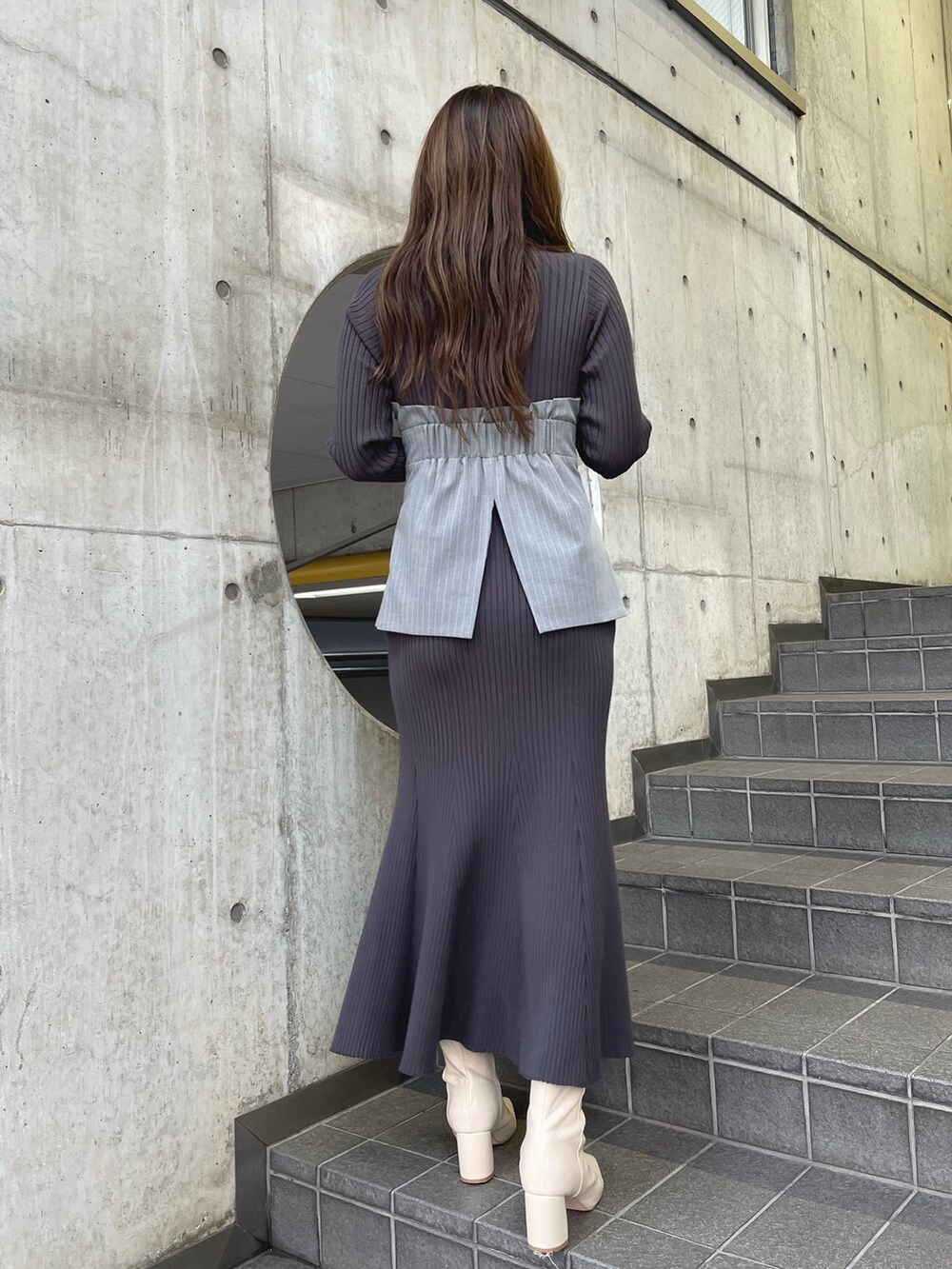 グレー系のワンピース、ホワイト系のブーツを着用したレディースの冬コーディネートの4枚目の写真