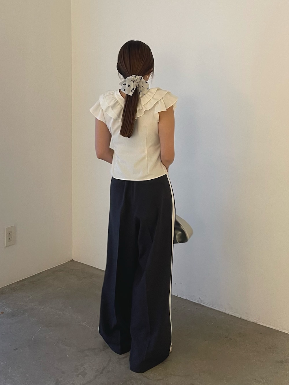 シルバー系のハンドバッグ、ホワイト系のシャツ/ブラウス、グレー系のその他パンツを着用したレディースの春コーディネートの7枚目の写真